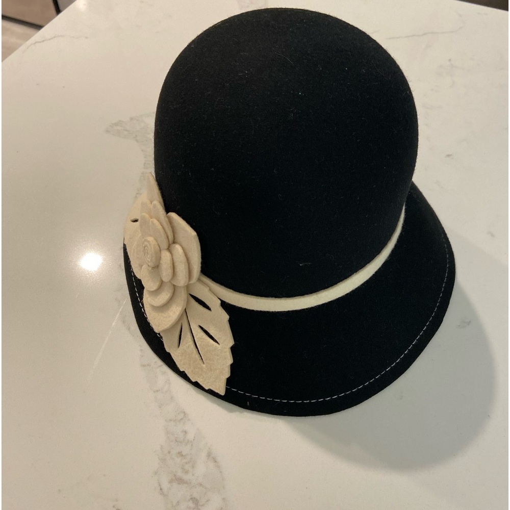 Black wool hat piped in cream with flower on the side